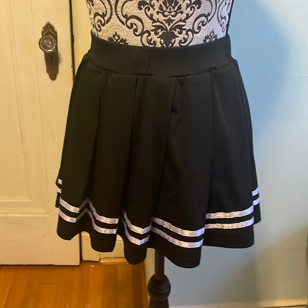 Black pleated mini skirt with white border